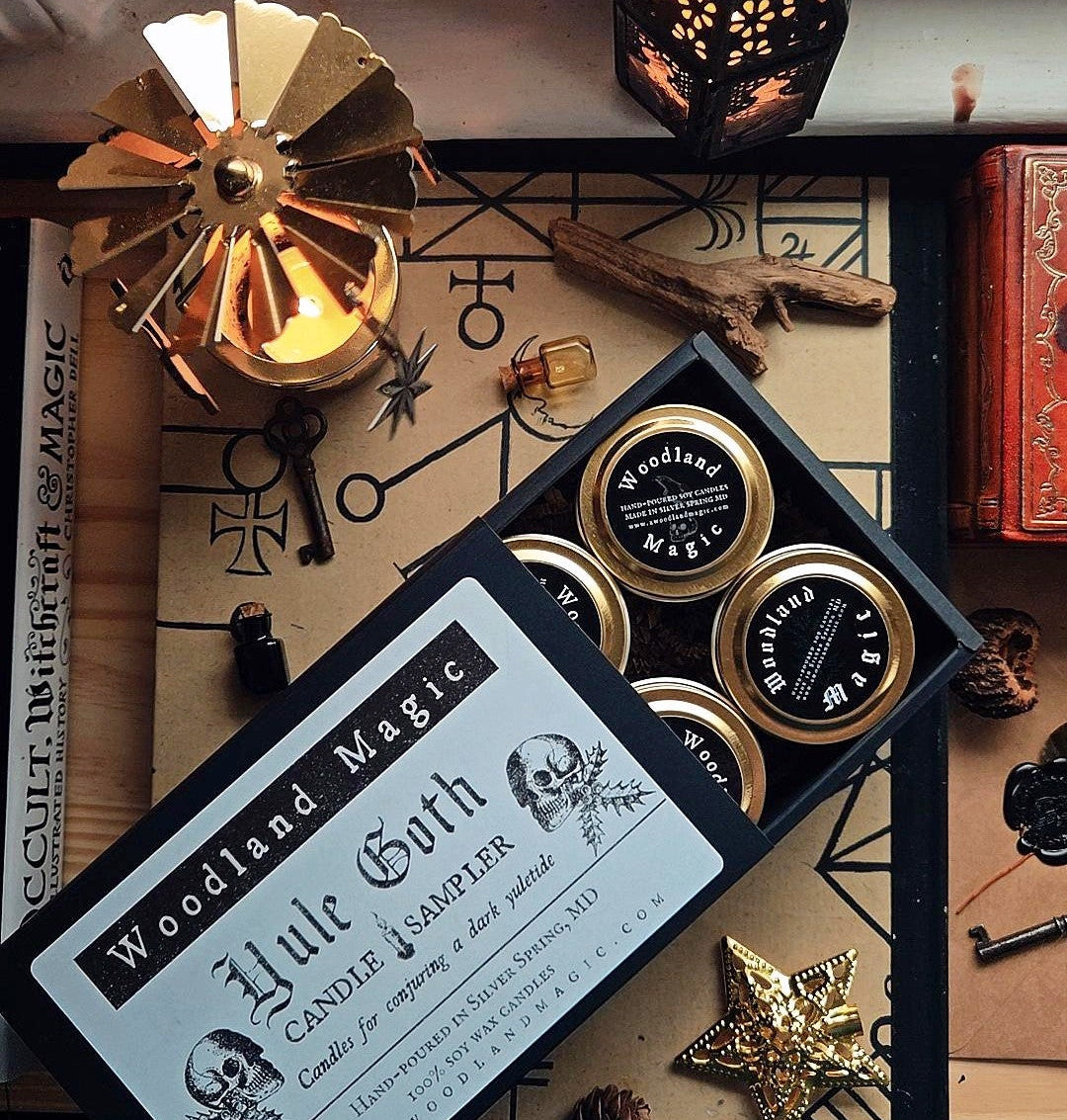 Candle sampler set with decorative packaging on a gothic-themed surface
