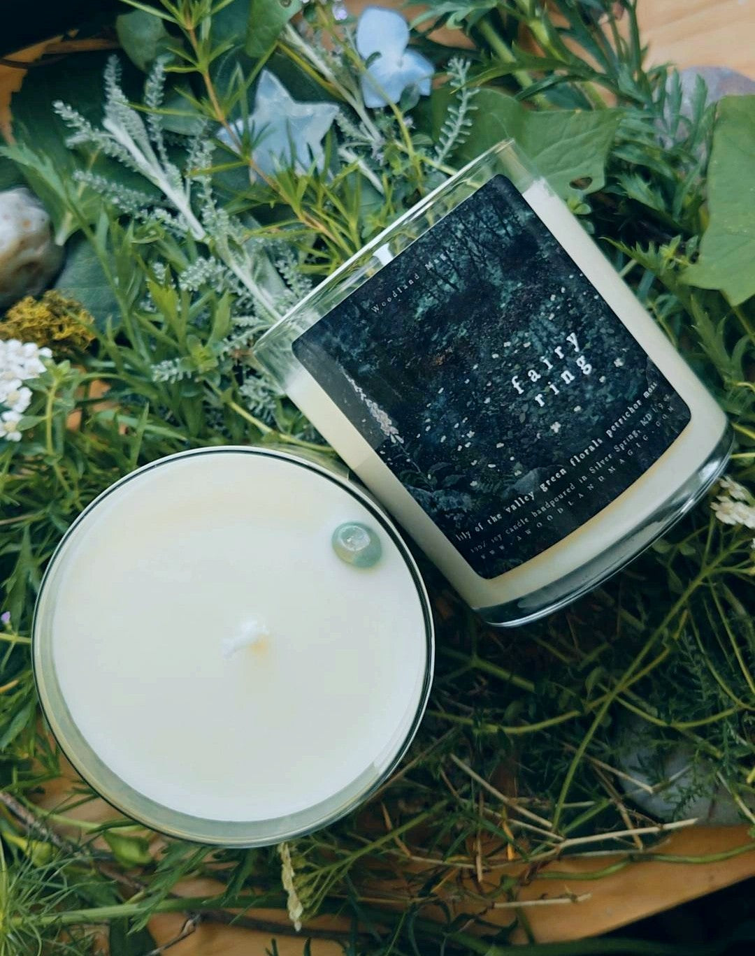 Candle labeled "fairy ring" on a bed of greenery