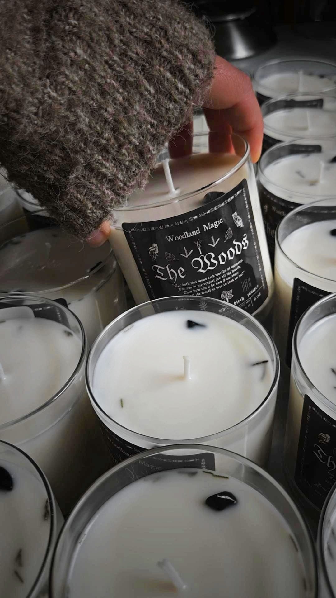 Candles with 'The Woods' label surrounded by other candles